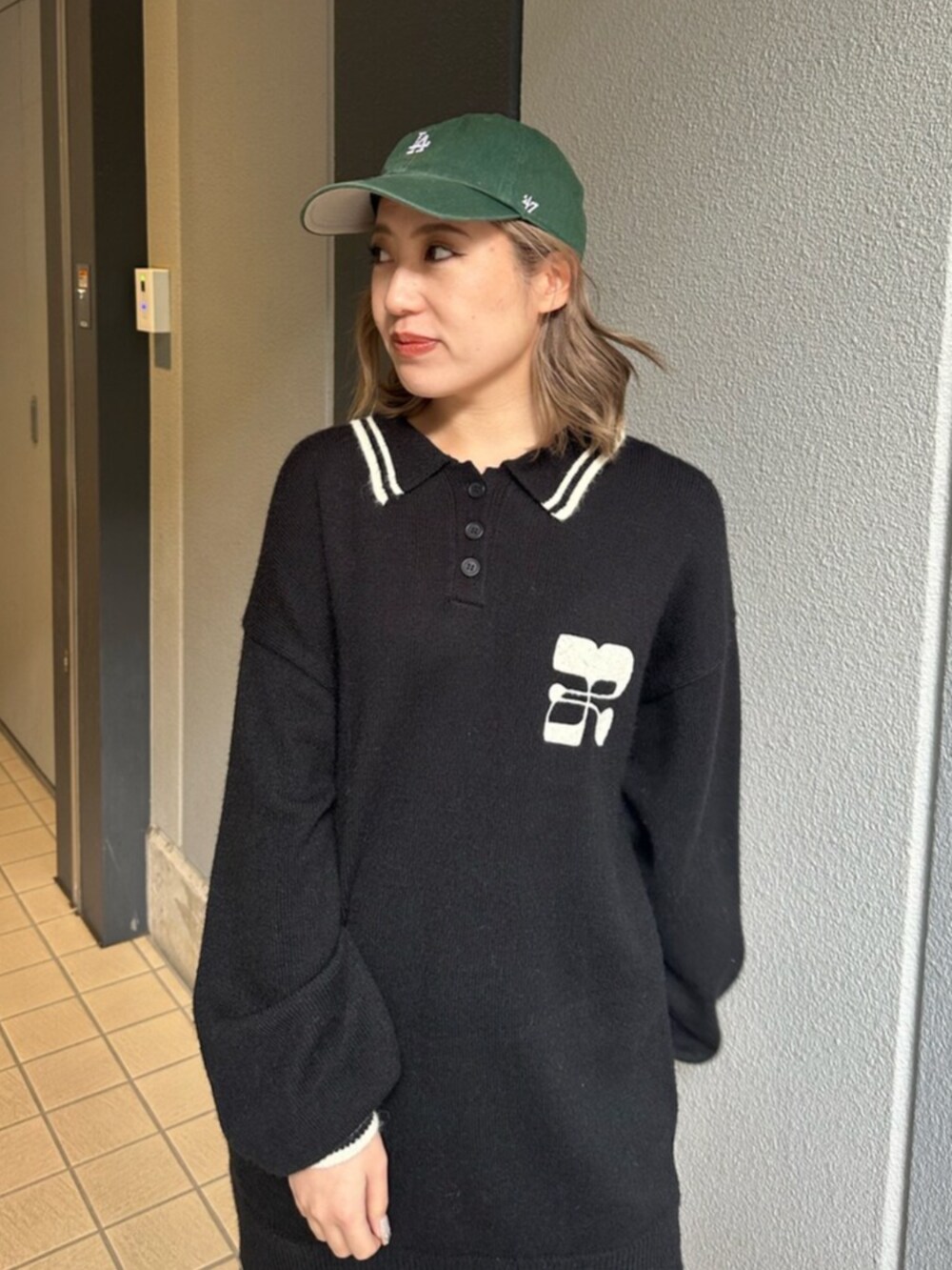 ブラック系のブーツ、ブルー系のデニムスカート、ブラック系のニット/セーターを着用したレディースの冬コーディネートの4枚目の写真