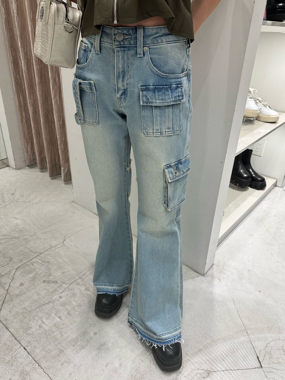 グリーン系のキャミソール、ブルー系のデニムパンツ、ホワイト系のショルダーバッグを着用したレディースの冬コーディネートの8枚目の写真