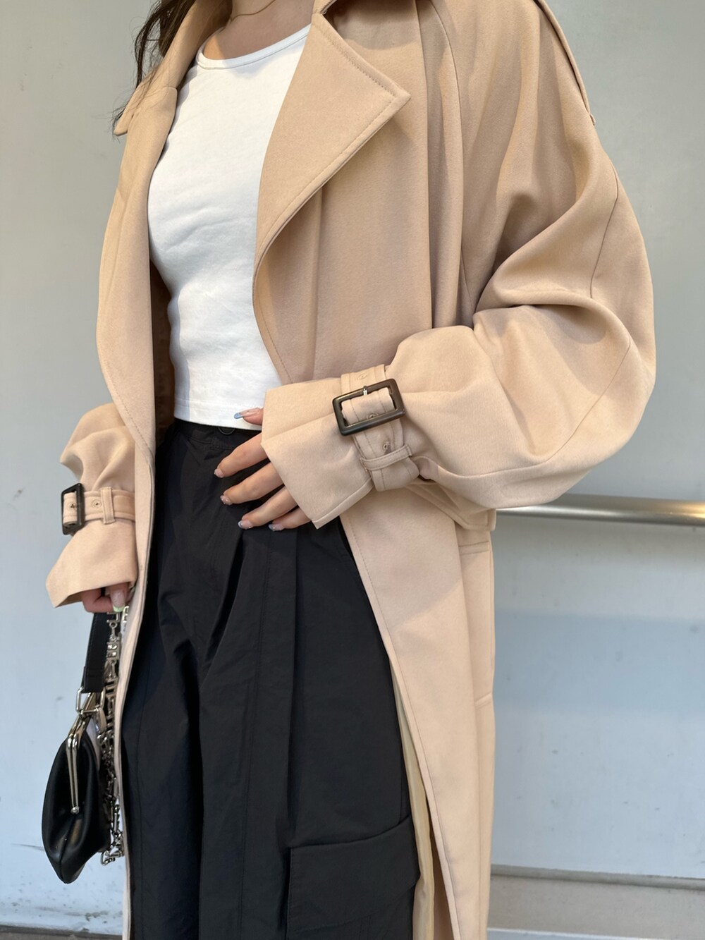 ベージュ系のトレンチコート、ブラック系のカーゴパンツ、ホワイト系のTシャツ/カットソーを着用したレディースの春コーディネートの4枚目の写真