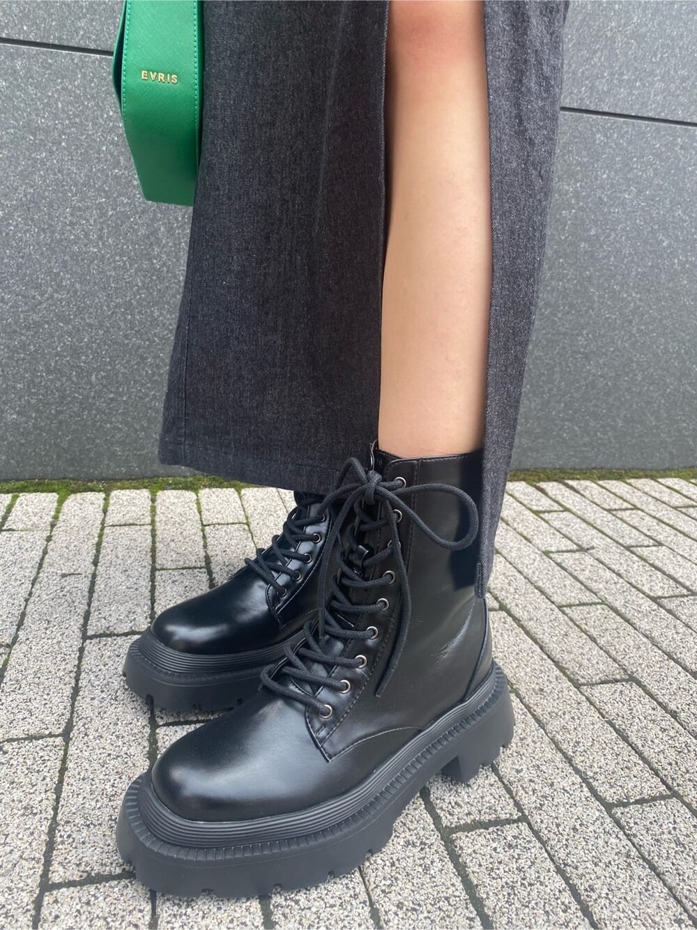 ブラック系のワンピース、グリーン系のショルダーバッグ、ブラック系のブーツを着用したレディースの夏コーディネートの8枚目の写真