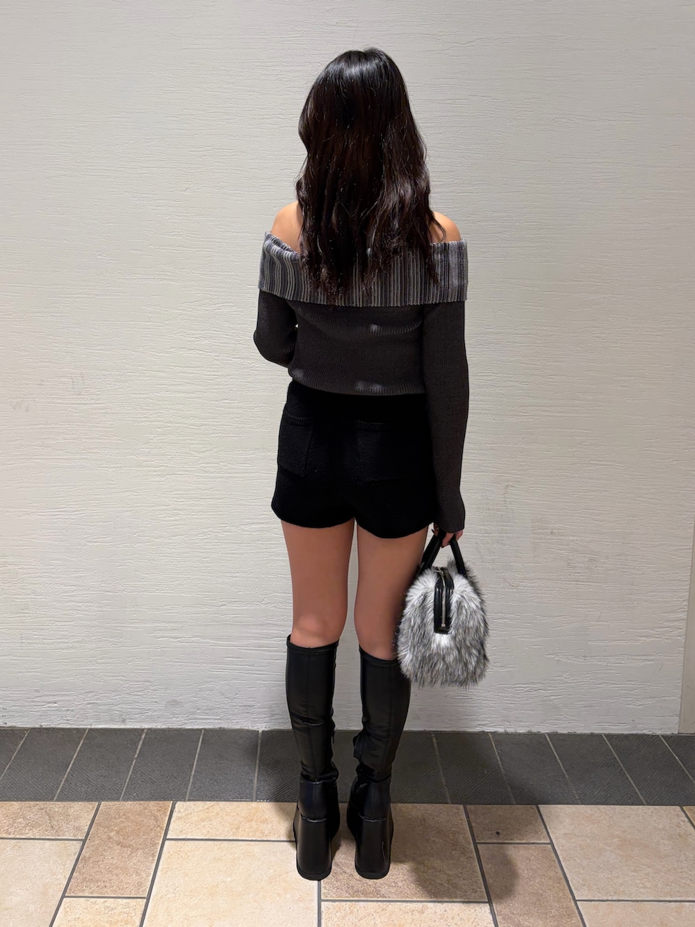 ブラック系のブーツ、ブラック系のその他パンツ、ブラック系のボストンバッグを着用したレディースの秋コーディネートの4枚目の写真