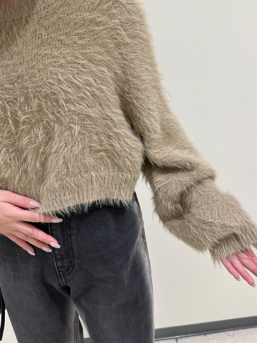 ベージュ系のニット/セーター、ブラック系のショルダーバッグ、ブラック系のブーツを着用したレディースの冬コーディネートの5枚目の写真