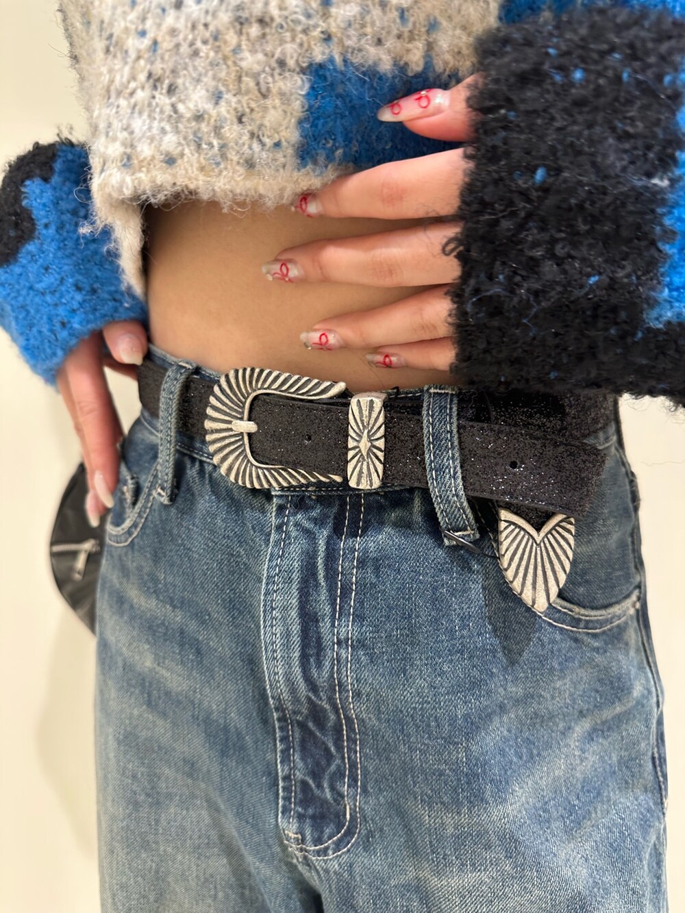 ブルー系のデニムパンツ、ブラック系のショルダーバッグ、ブラック系のブーツを着用したレディースの冬コーディネートの7枚目の写真