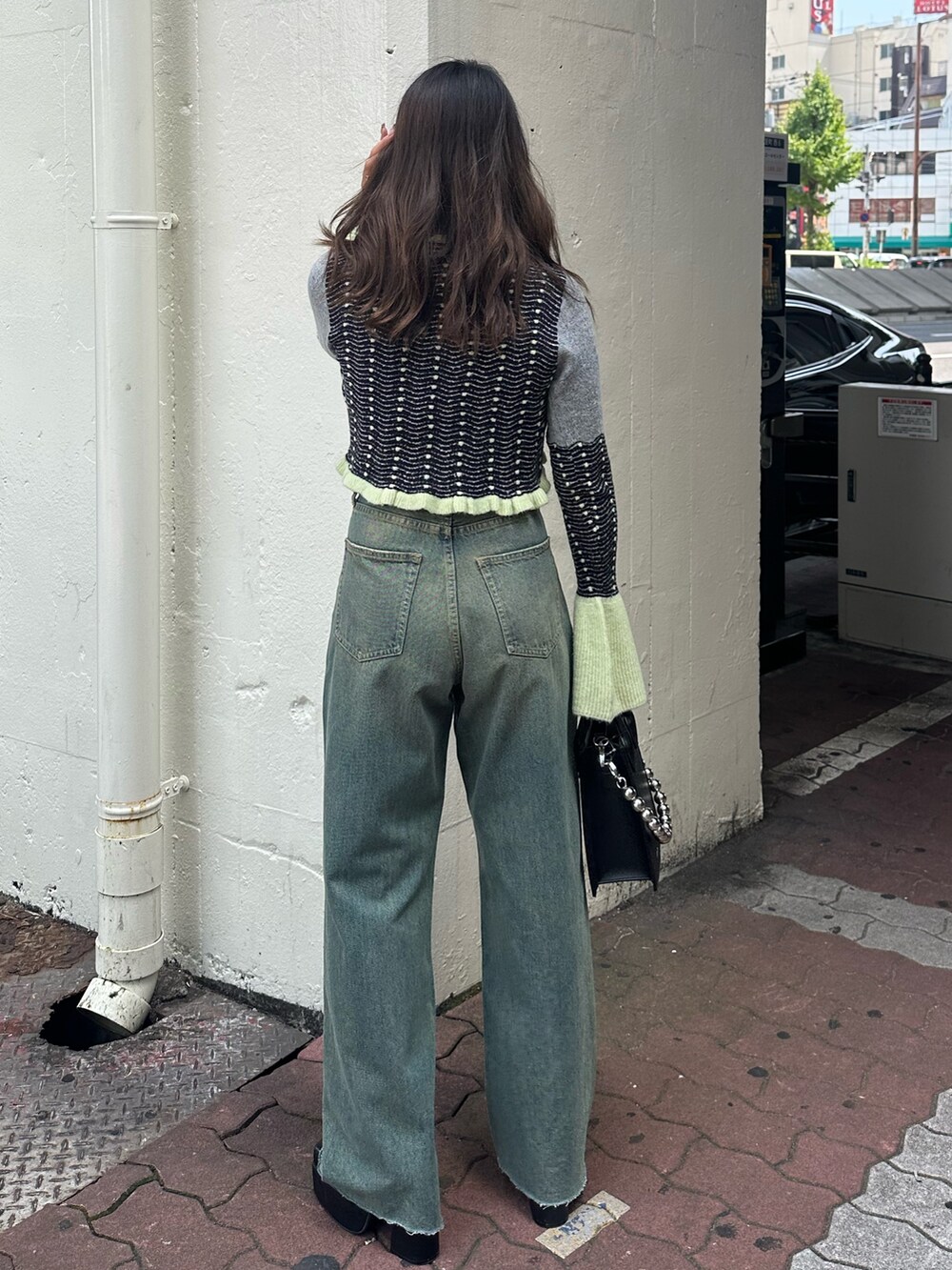 イエロー系のニット/セーター、ブルー系のデニムパンツ、ブラック系のショルダーバッグを着用したレディースの秋コーディネートの3枚目の写真