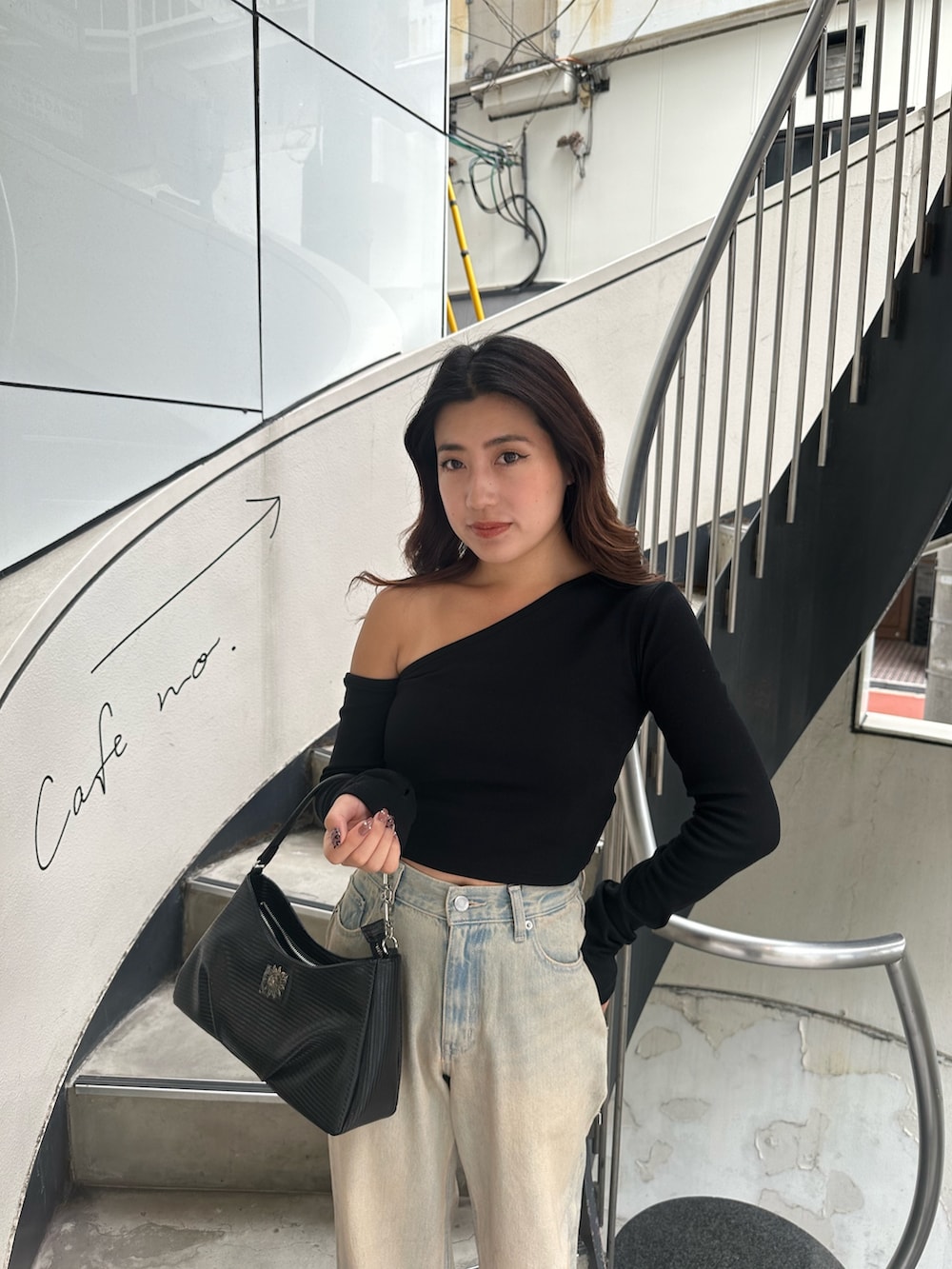 ブルー系のデニムパンツ、ブラック系のサンダル、ブラック系のTシャツ/カットソーを着用したレディースの秋コーディネートの4枚目の写真