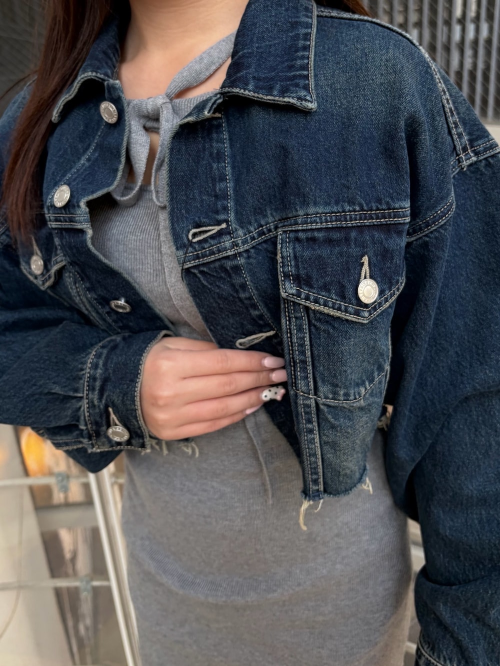 ブラック系のブーツ、ブルー系のデニムジャケット、グレー系のワンピースを着用したレディースの冬コーディネートの6枚目の写真