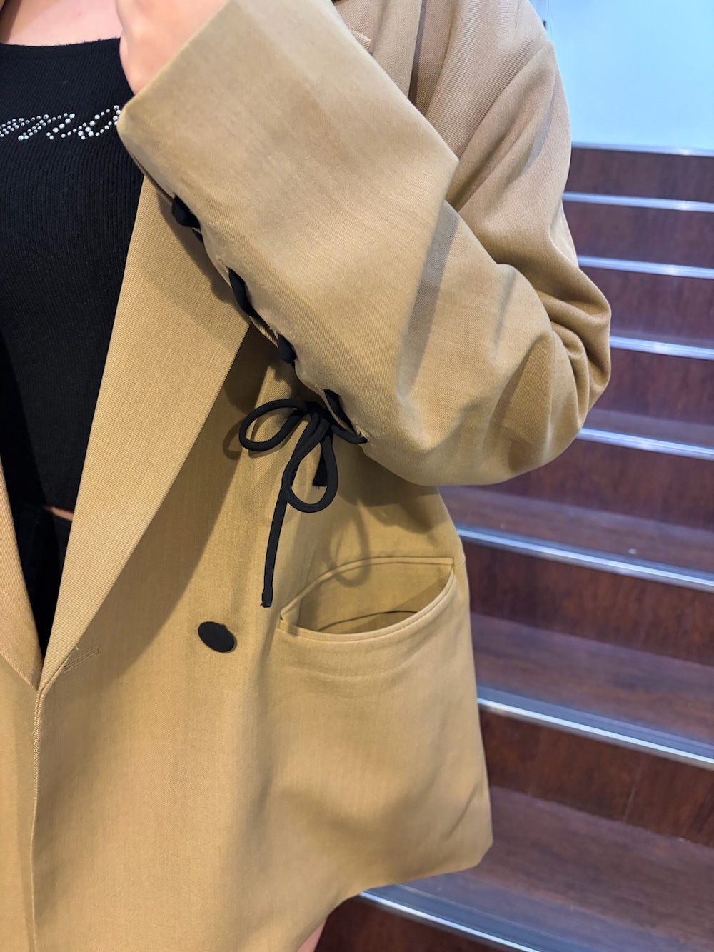 ブラウン系のテーラードジャケット、ブラック系のニット/セーター、ブラック系のその他パンツを着用したレディースの春コーディネートの7枚目の写真