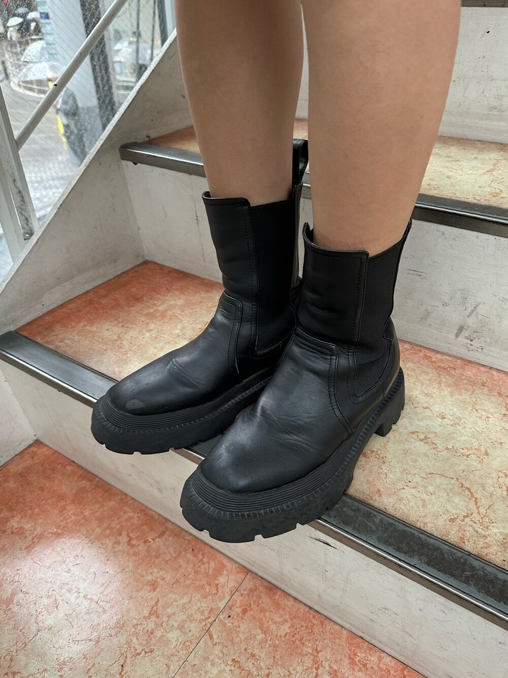 ホワイト系のTシャツ/カットソー、ブラック系のブーツ、ブラック系のハンドバッグを着用したレディースの夏コーディネートの8枚目の写真