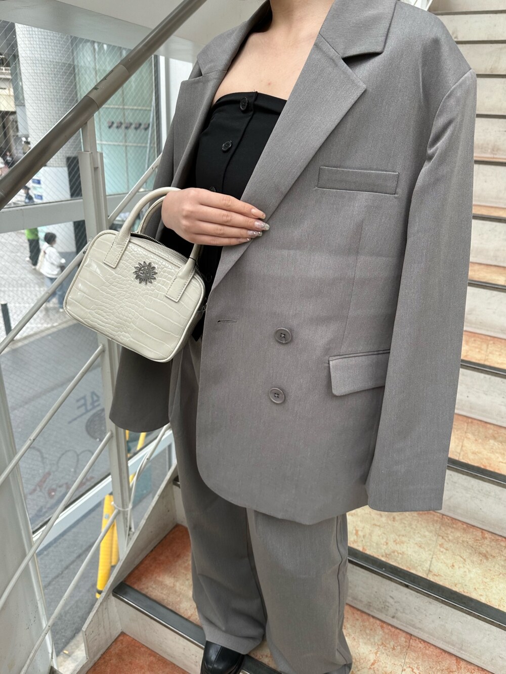 グレー系のその他パンツ、ブラック系のキャミソール、グレー系のテーラードジャケットを着用したレディースの春コーディネートの6枚目の写真