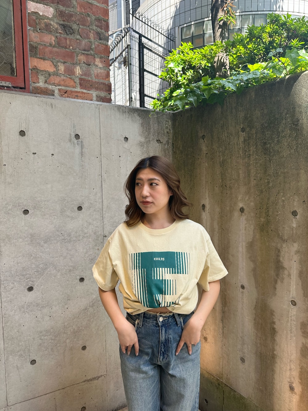 イエロー系のTシャツ/カットソー、ブルー系のデニムパンツ、ブラウン系のブーツを着用したレディースの春コーディネートの4枚目の写真