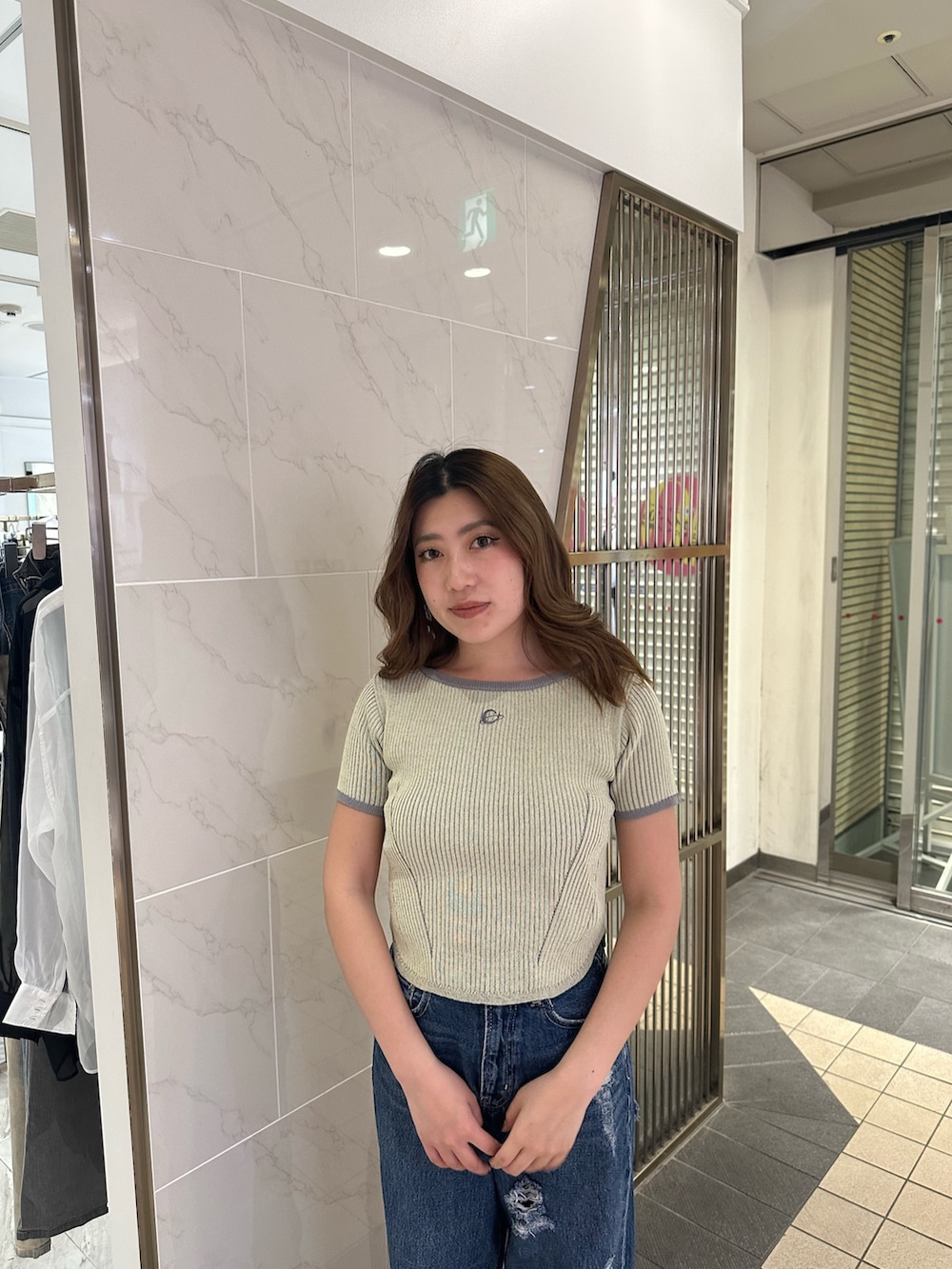 ブルー系のデニムパンツ、ブラック系のサンダル、イエロー系のニット/セーターを着用したレディースの春コーディネートの4枚目の写真