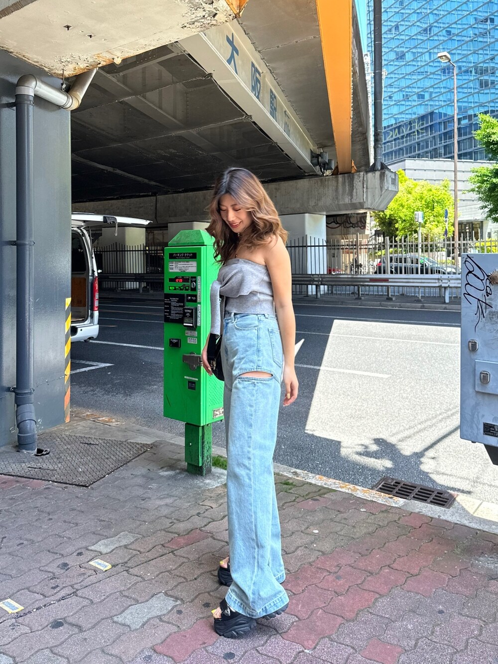 ブラック系のサンダル、ブラック系のショルダーバッグ、グレー系のチューブトップを着用したレディースの春コーディネートの2枚目の写真