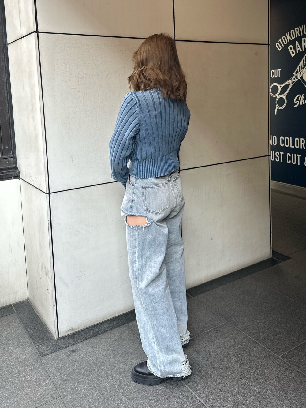 ブルー系のデニムパンツ、ブラック系のブーツ、ブルー系のカーディガン/ボレロを着用したレディースの冬コーディネートの3枚目の写真