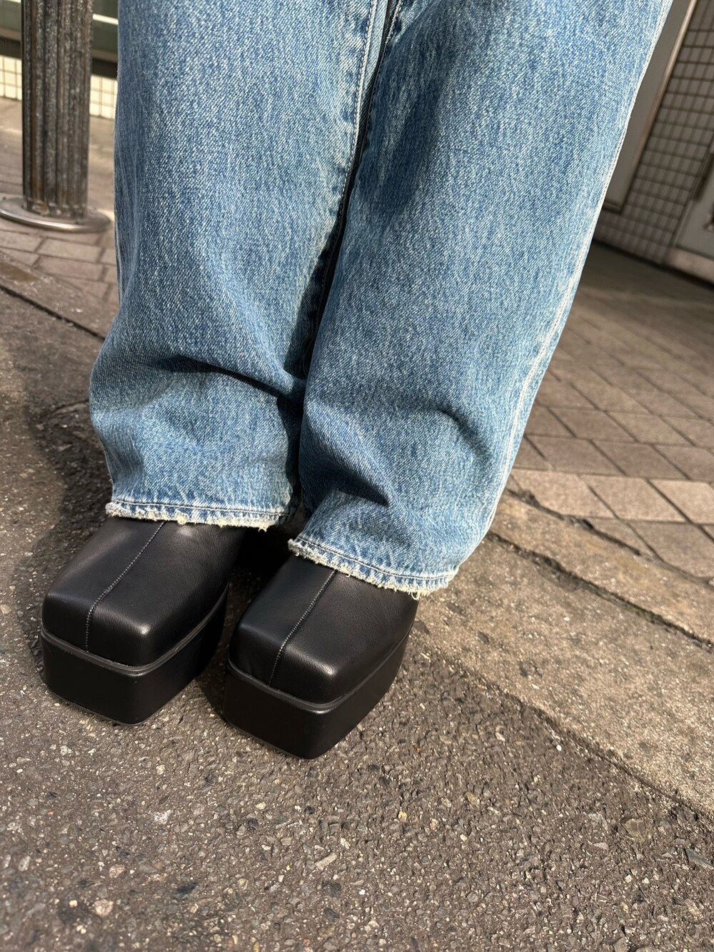 イエロー系のニット/セーター、ブルー系のデニムパンツ、ブラック系のショルダーバッグを着用したレディースの冬コーディネートの8枚目の写真