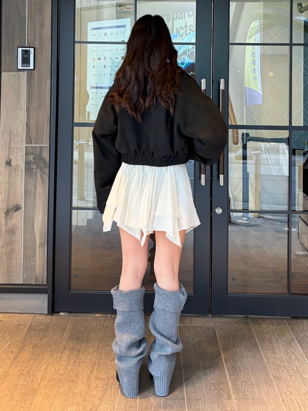 ブラック系のブルゾン、ホワイト系のニット/セーター、ホワイト系のスカートを着用したレディースの冬コーディネートの3枚目の写真