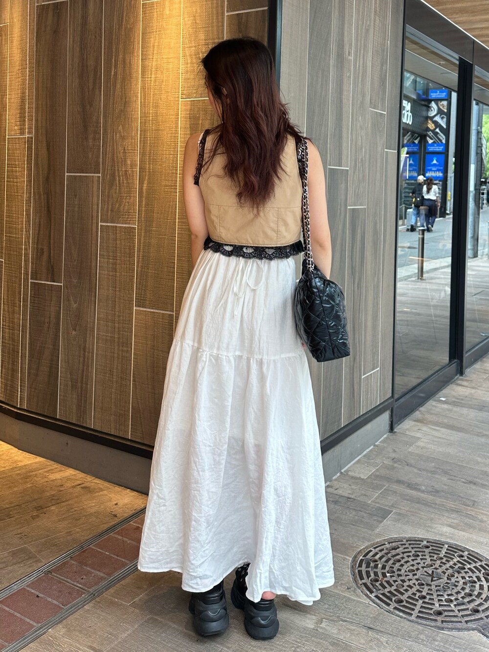 ホワイト系のワンピース、ベージュ系のシャツ/ブラウス、ブラック系のショルダーバッグを着用したレディースの夏コーディネートの3枚目の写真