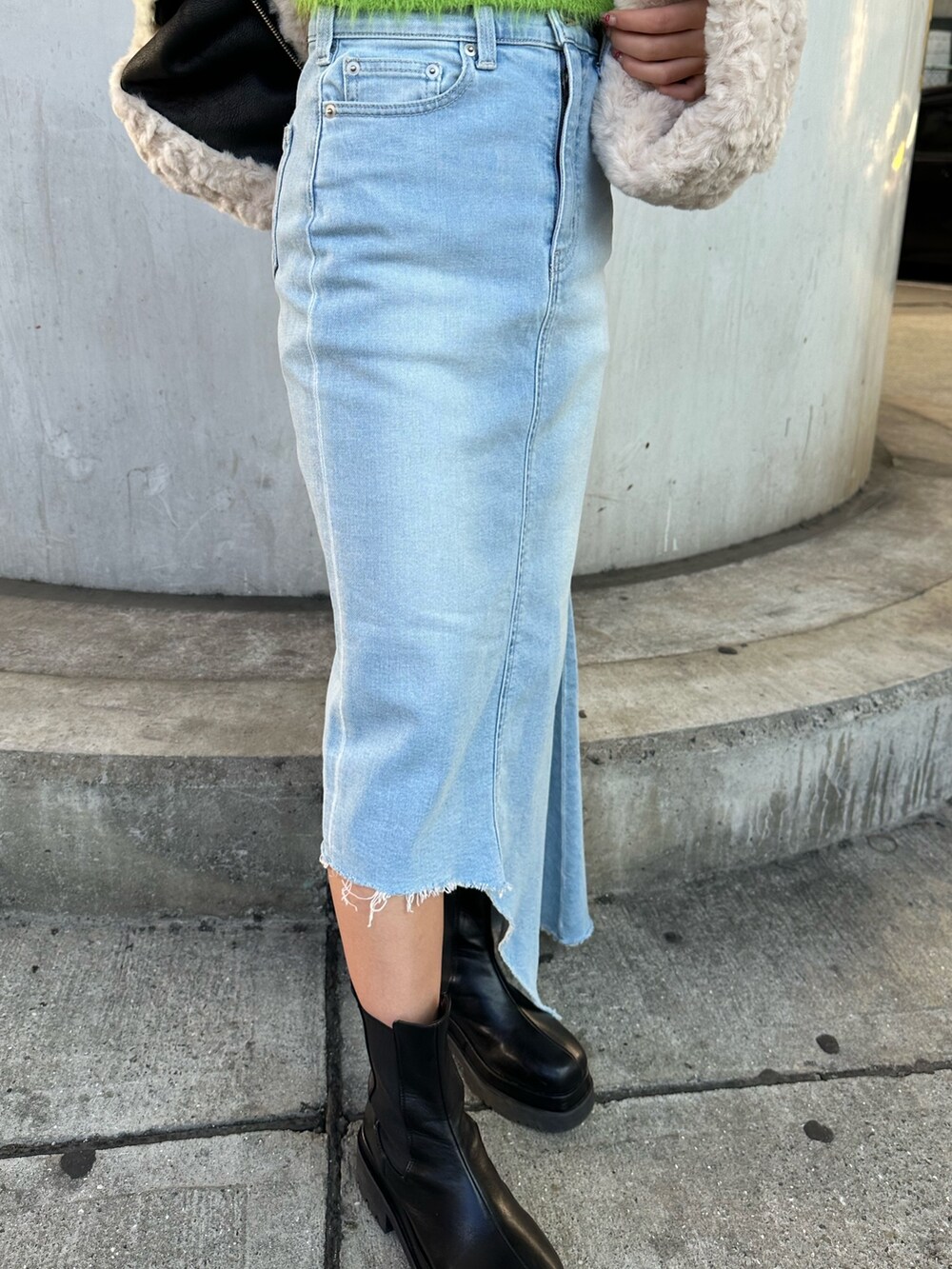 ブルー系のデニムスカート、グリーン系のニット/セーター、ブラック系のムートンコートを着用したレディースの冬コーディネートの6枚目の写真