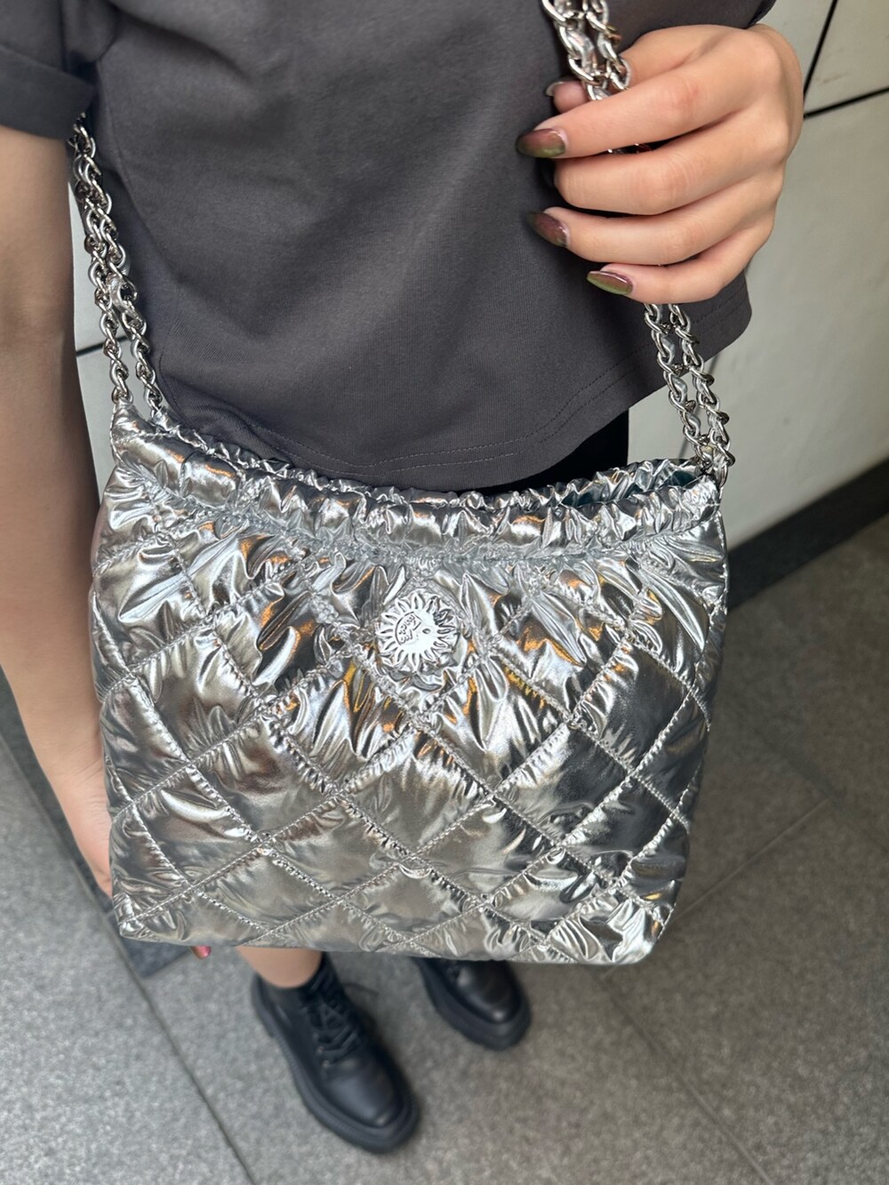 ブラック系のその他パンツ、シルバー系のショルダーバッグ、ブラック系のブーツを着用したレディースの春コーディネートの5枚目の写真