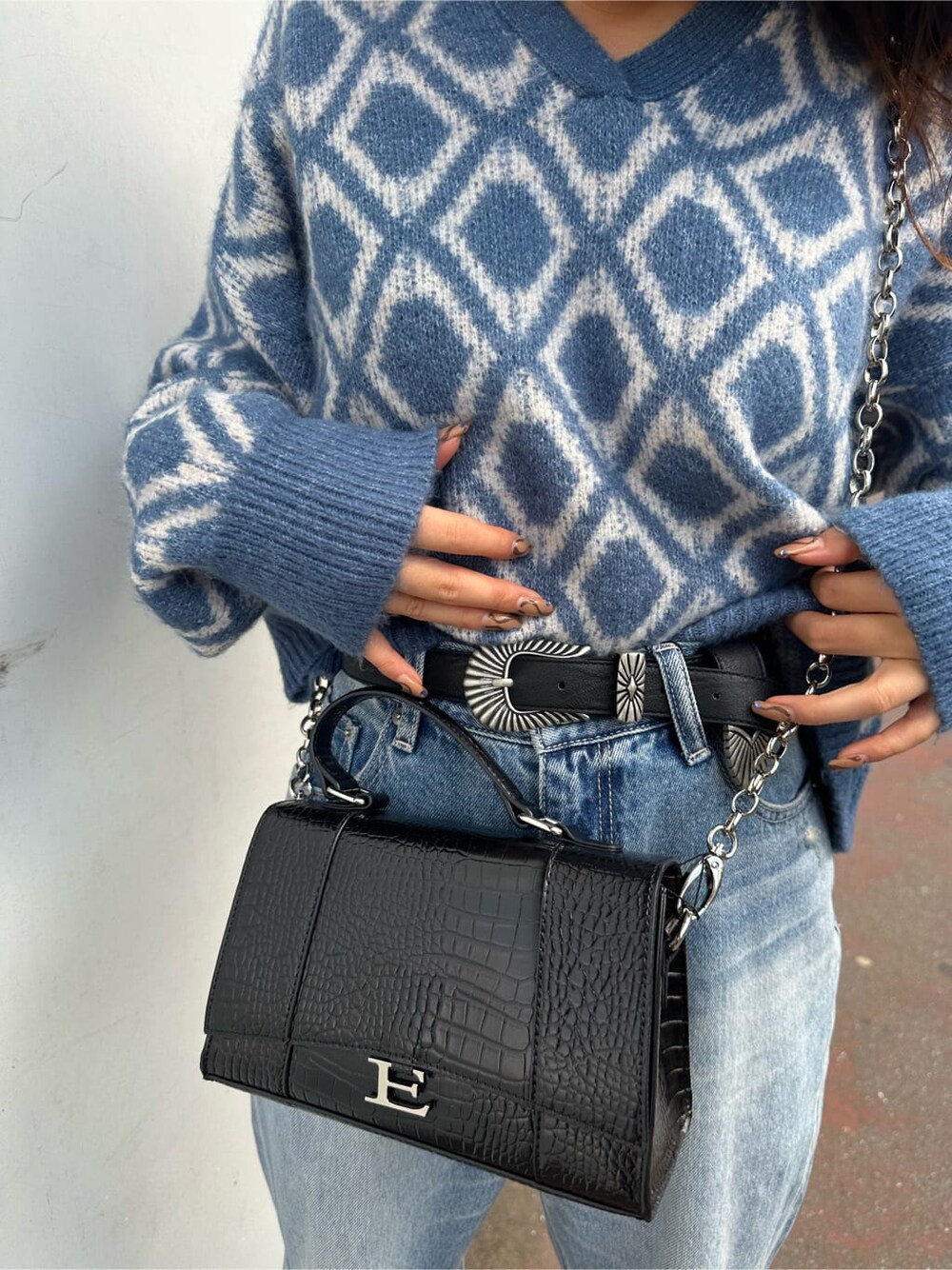 ブラック系のブーツ、ブルー系のニット/セーター、ブルー系のデニムパンツを着用したレディースの秋コーディネートの5枚目の写真