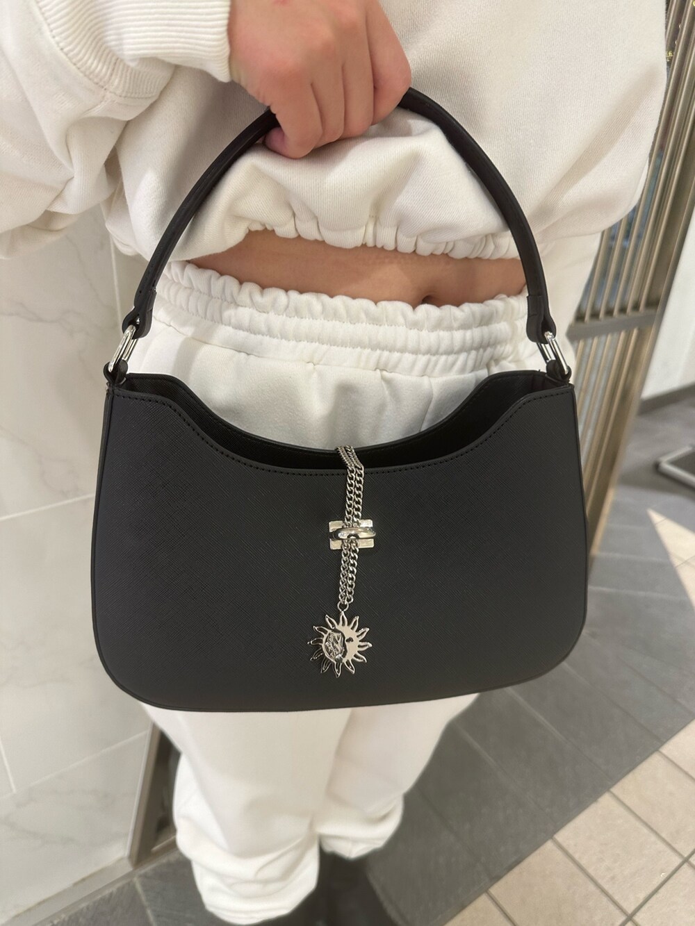 ホワイト系のスウェットパンツ、ホワイト系のスウェット、ブラック系のブーツを着用したレディースの秋コーディネートの6枚目の写真