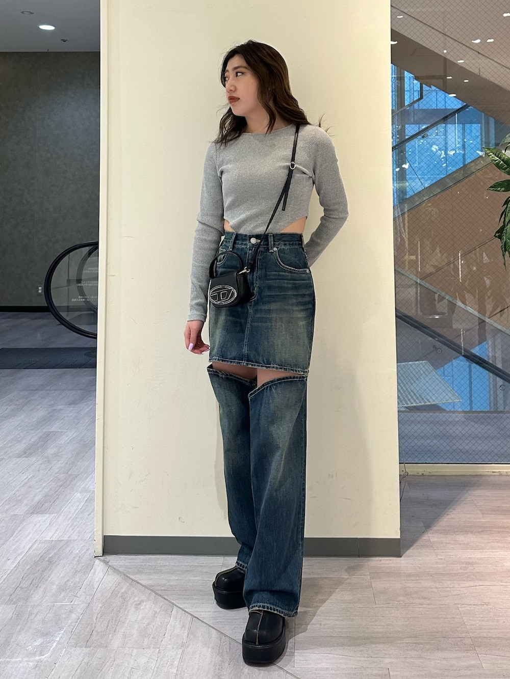 ブルー系のデニムパンツ、グレー系のTシャツ/カットソー、ブラック系のブーツを着用したレディースの冬コーディネートの2枚目の写真