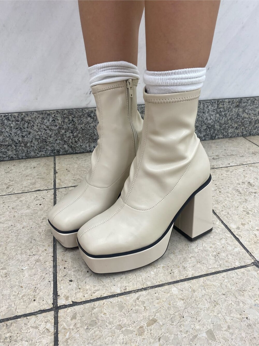 ホワイト系のブーツ、イエロー系のジャンパースカート、ブラック系のショルダーバッグを着用したレディースの夏コーディネートの8枚目の写真