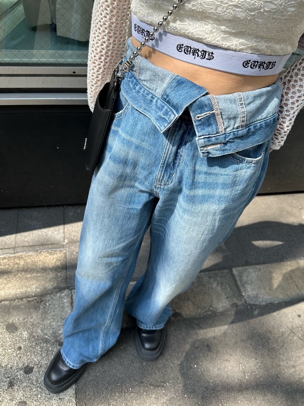 ブルー系のデニムパンツ、ホワイト系のキャミソール、ホワイト系のニット/セーターを着用したレディースの春コーディネートの6枚目の写真