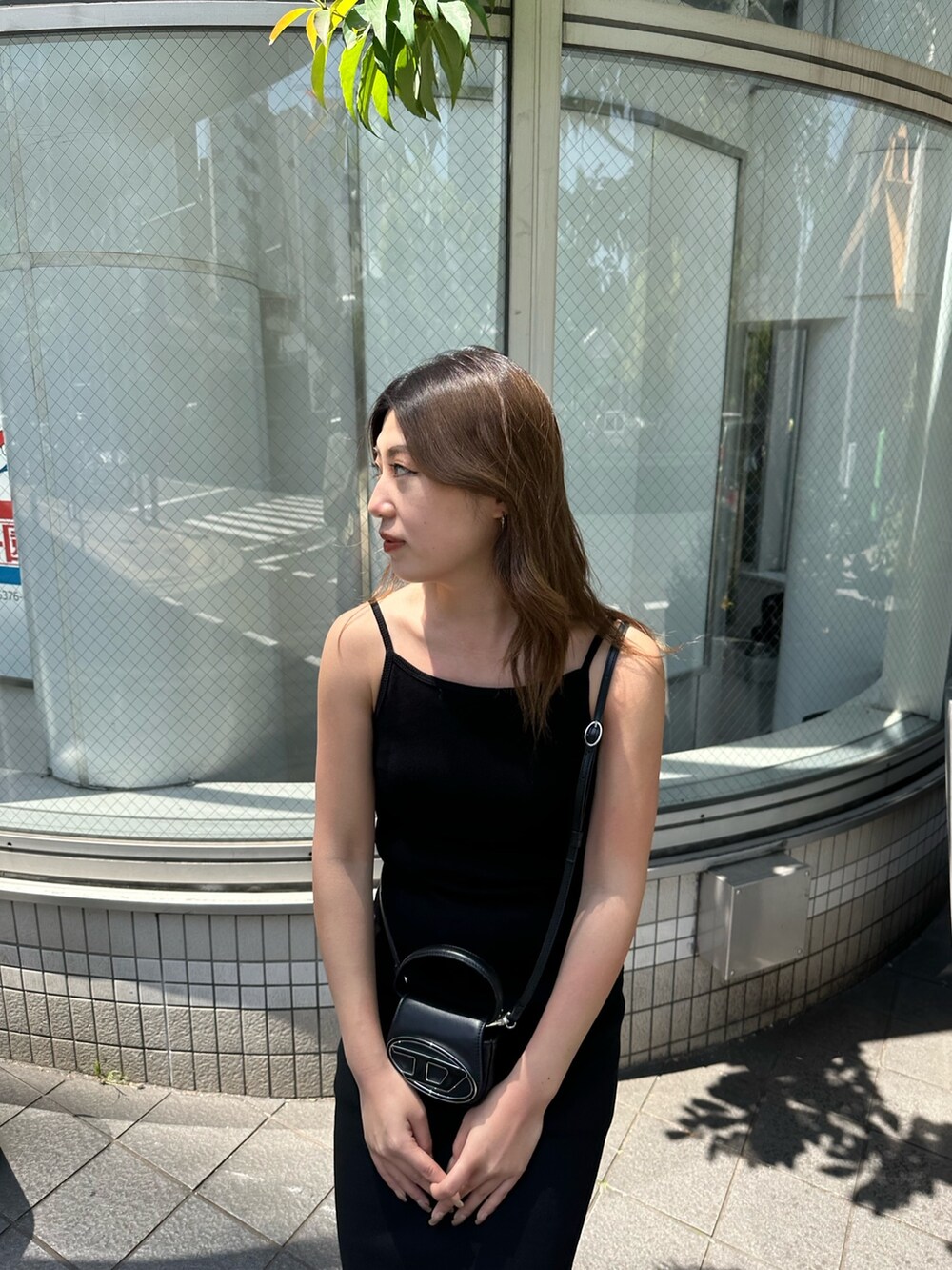 ブラック系のワンピース、ブラック系のブーツ、ホワイト系のキャップを着用したレディースの春コーディネートの4枚目の写真