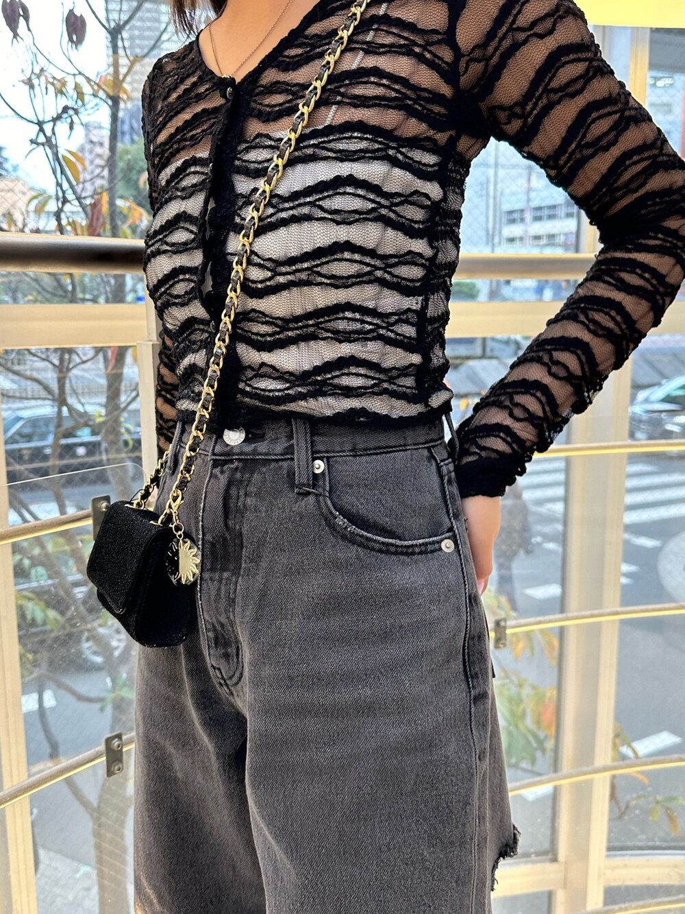 ブラック系のショルダーバッグ、ブラック系のデニムパンツ、ブラック系のTシャツ/カットソーを着用したレディースの冬コーディネートの4枚目の写真