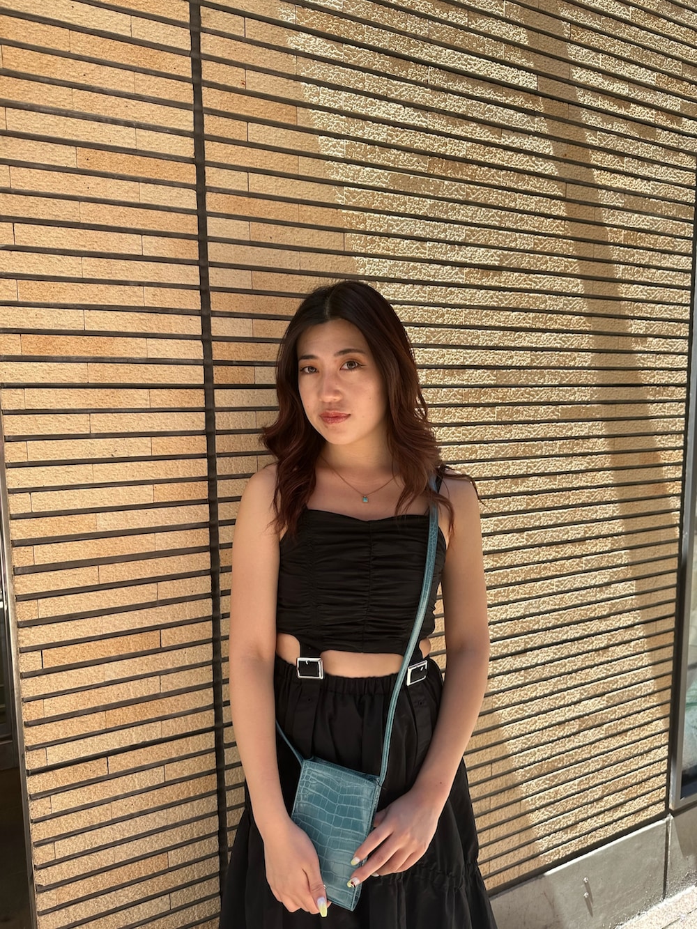 ブラック系のサンダル、ブルー系のショルダーバッグ、ブラック系のワンピースを着用したレディースの夏コーディネートの5枚目の写真