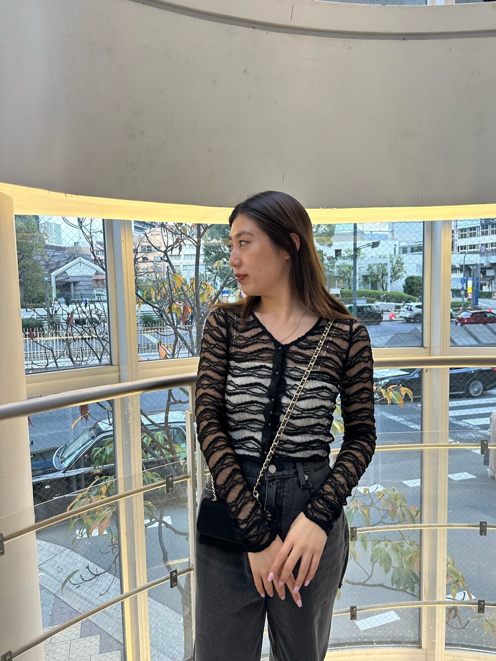 ブラック系のショルダーバッグ、ブラック系のデニムパンツ、ブラック系のTシャツ/カットソーを着用したレディースの冬コーディネートの3枚目の写真