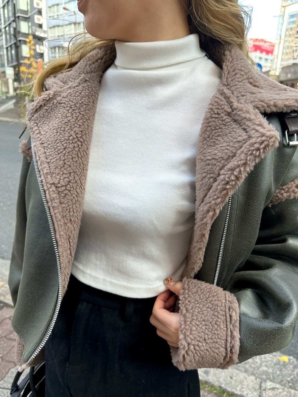 ベージュ系のブルゾン、ブラック系のショルダーバッグ、ブラック系のブーツを着用したレディースの冬コーディネートの4枚目の写真