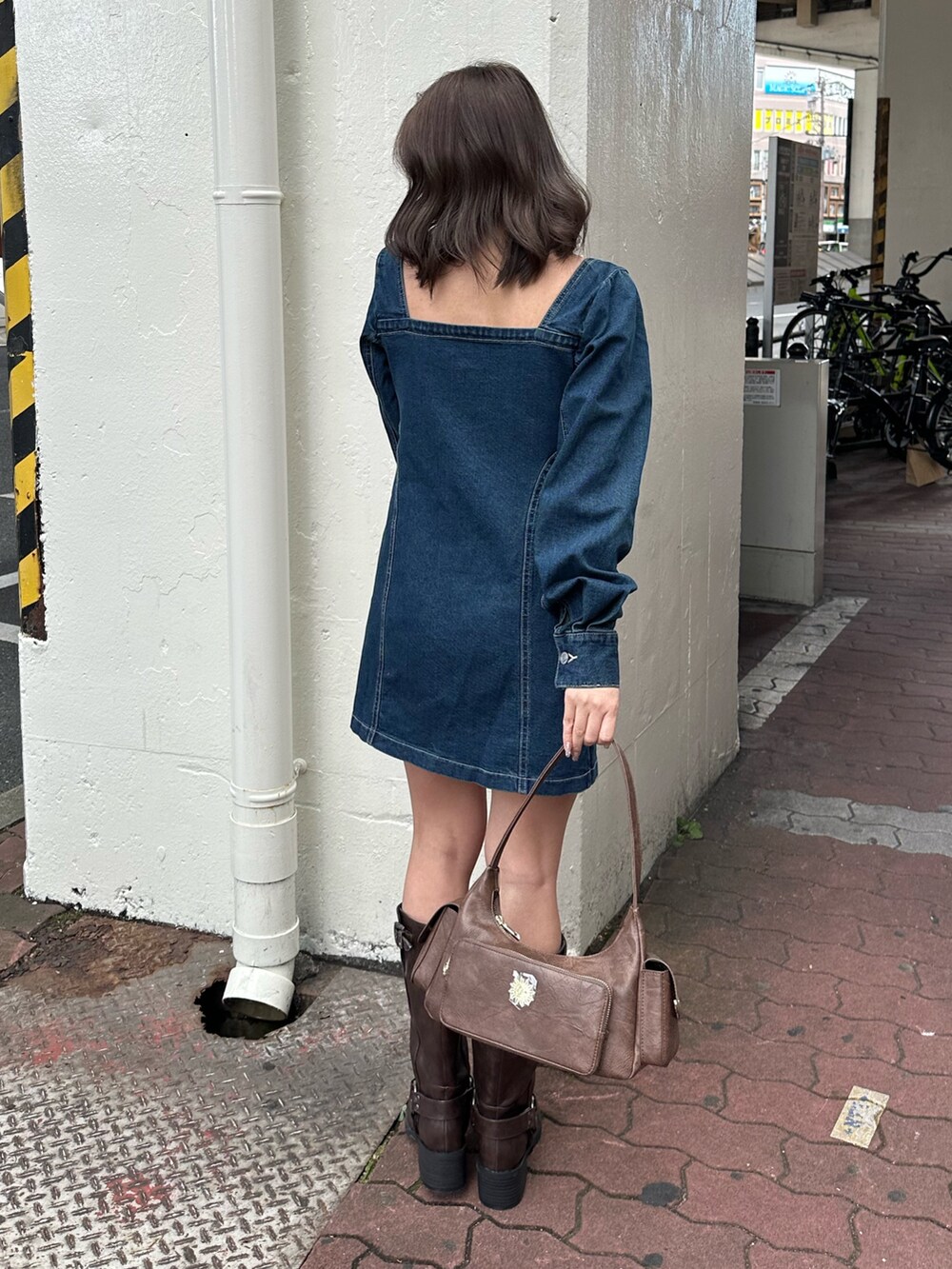 ブラウン系のブーツ、ブルー系のワンピース、ブラウン系のハンドバッグを着用したレディースの冬コーディネートの4枚目の写真