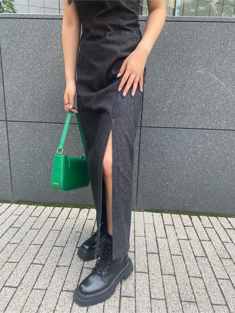 ブラック系のワンピース、グリーン系のショルダーバッグ、ブラック系のブーツを着用したレディースの夏コーディネートの6枚目の写真