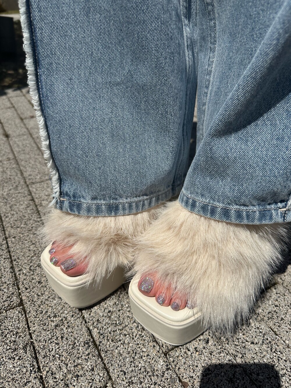 ホワイト系のタンクトップ、ホワイト系のサンダル、ブルー系のデニムパンツを着用したレディースの夏コーディネートの9枚目の写真