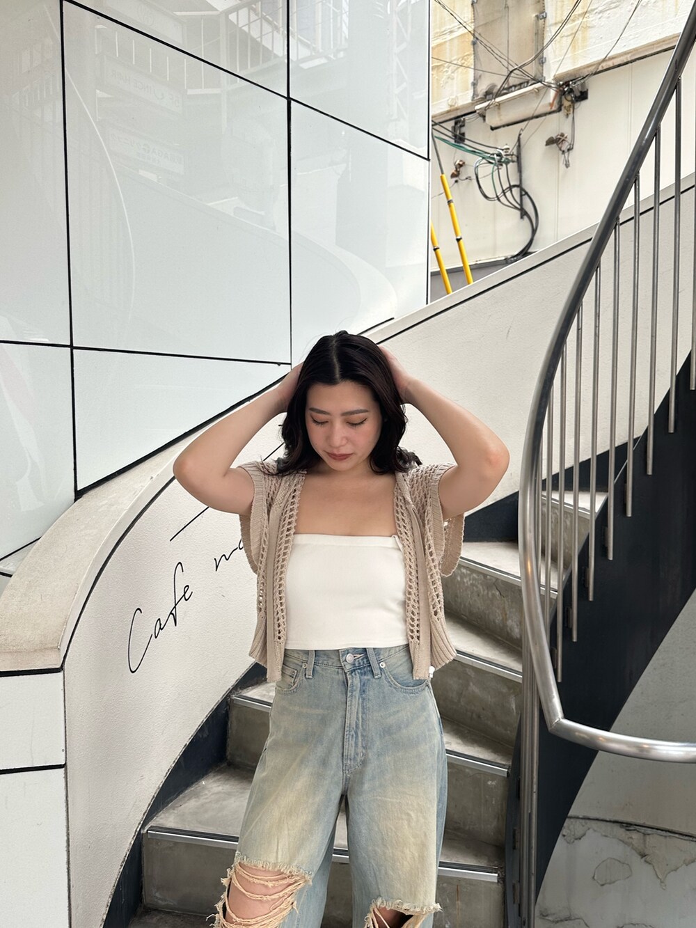 ホワイト系のニット/セーター、ブルー系のデニムパンツ、ブラック系のサンダルを着用したレディースの夏コーディネートの5枚目の写真