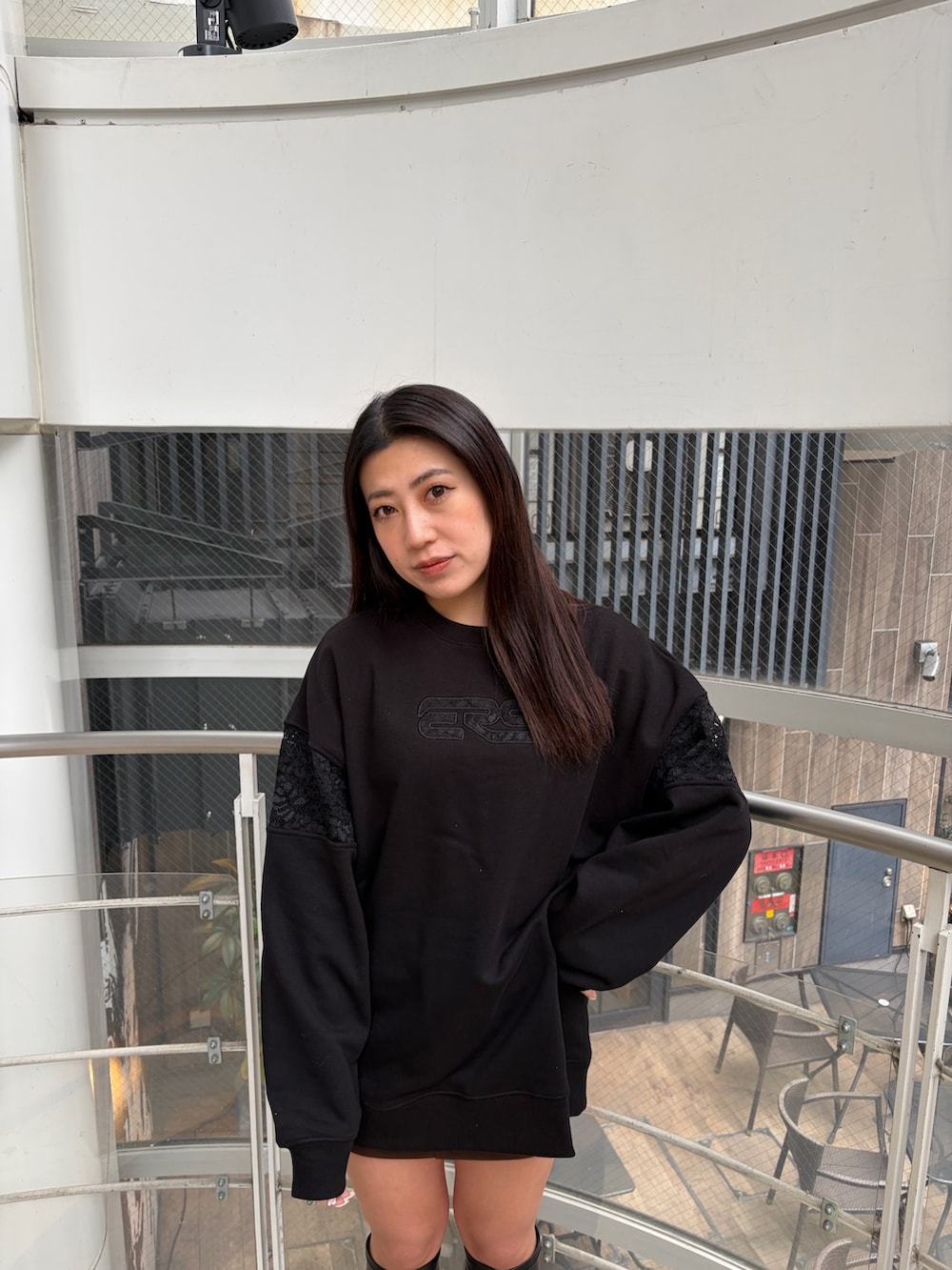 ブラック系のスウェット、ブラック系のブーツを着用したレディースの冬コーディネートの4枚目の写真