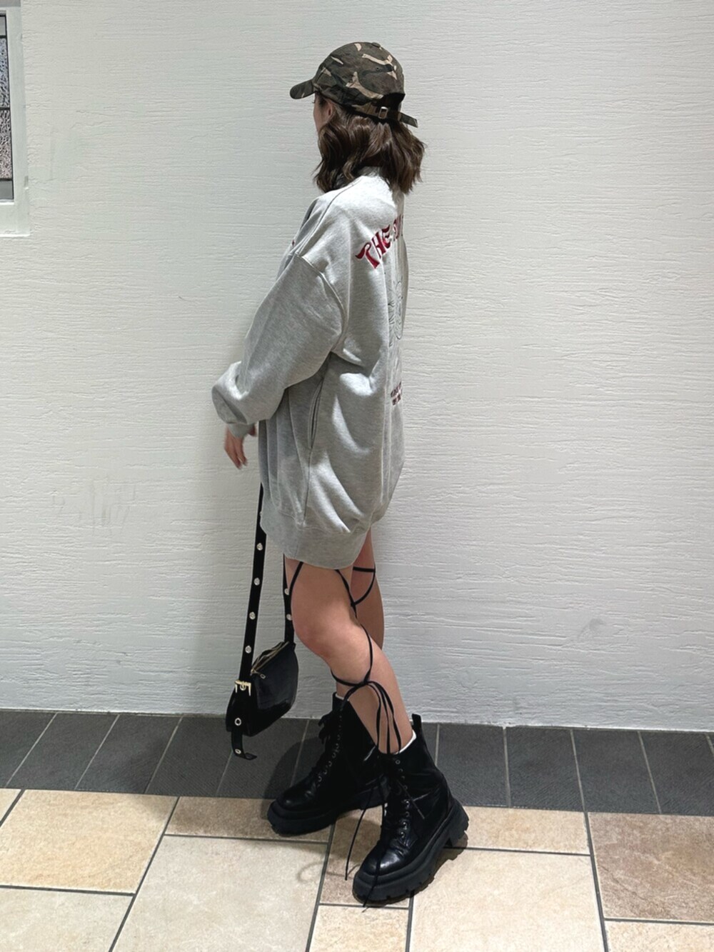 ブラック系のショルダーバッグ、ブラック系のブーツ、グレー系のスウェットを着用したレディースの冬コーディネートの3枚目の写真