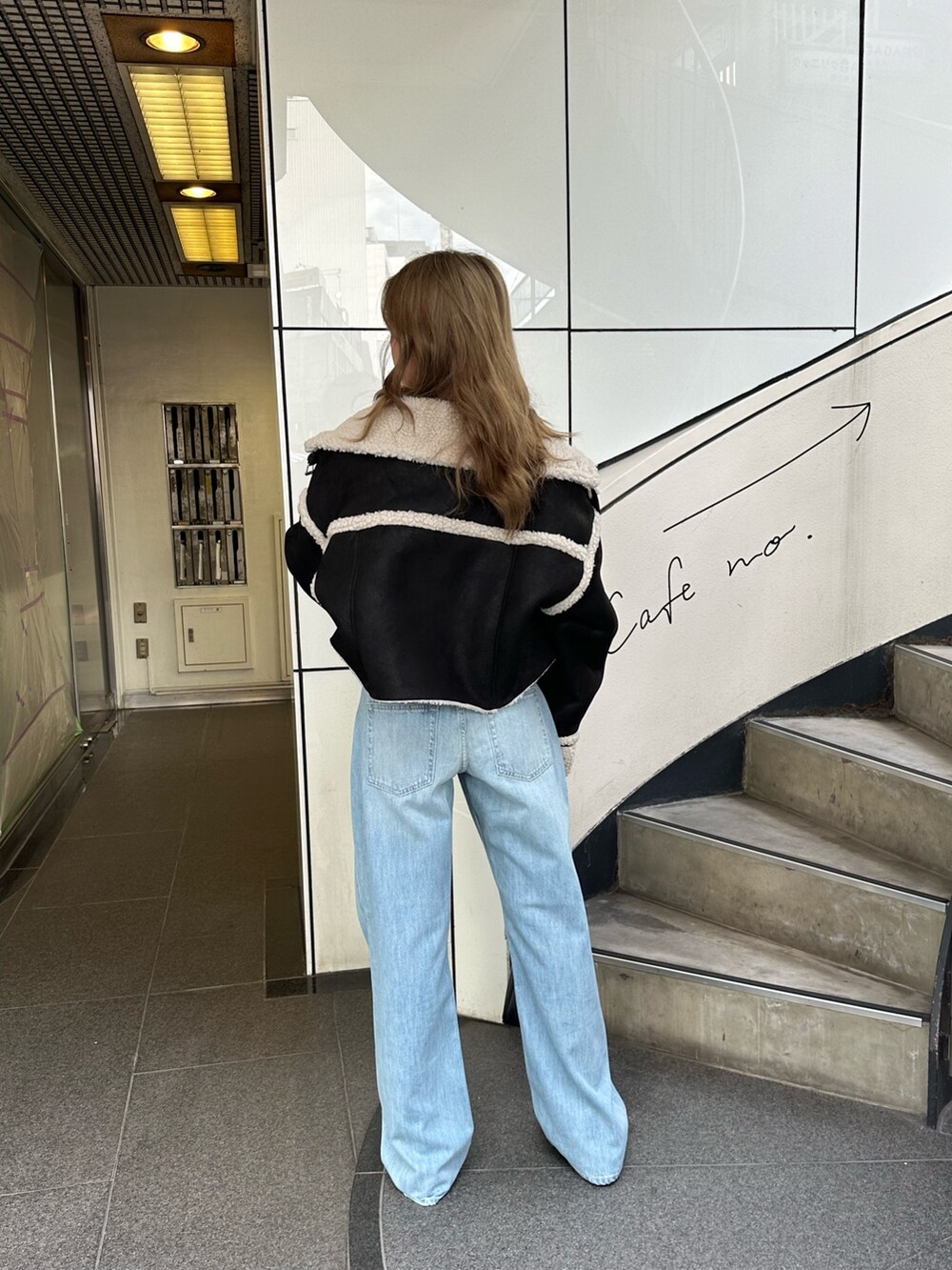 ブルー系のデニムパンツ、ブラック系のショルダーバッグ、グリーン系のチューブトップを着用したレディースの夏コーディネートの2枚目の写真