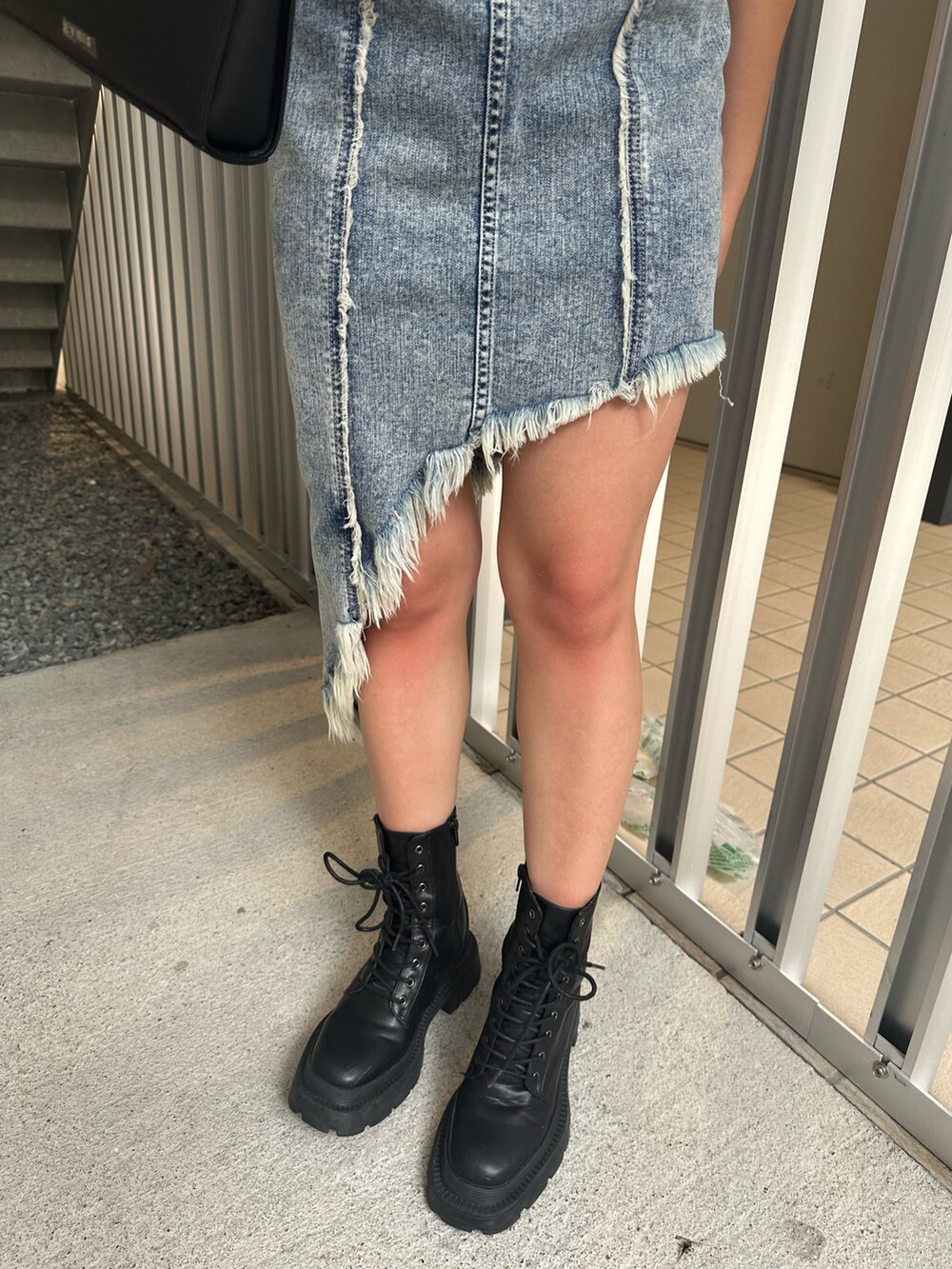 ブラック系のショルダーバッグ、ブラック系のブーツ、ブルー系のワンピースを着用したレディースの夏コーディネートの7枚目の写真