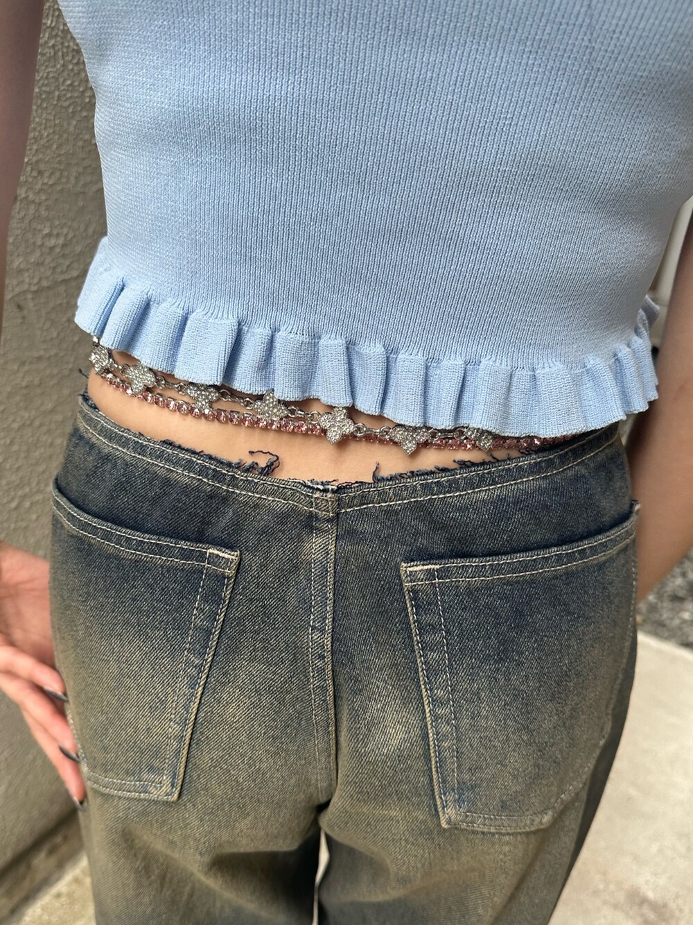 ブルー系のデニムパンツ、ブラック系のサンダル、ブルー系のキャミソールを着用したレディースの夏コーディネートの6枚目の写真