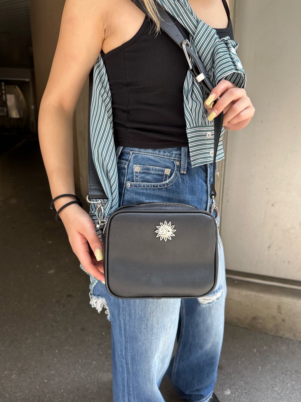 ブルー系のデニムパンツ、ブラック系のショルダーバッグ、グリーン系のシャツ/ブラウスを着用したレディースの夏コーディネートの9枚目の写真