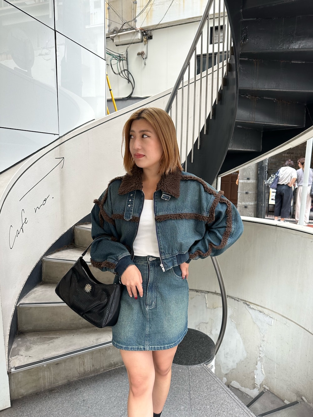 ブルー系のブルゾン、ブルー系のデニムスカート、その他のブーツを着用したレディースの秋コーディネートの4枚目の写真