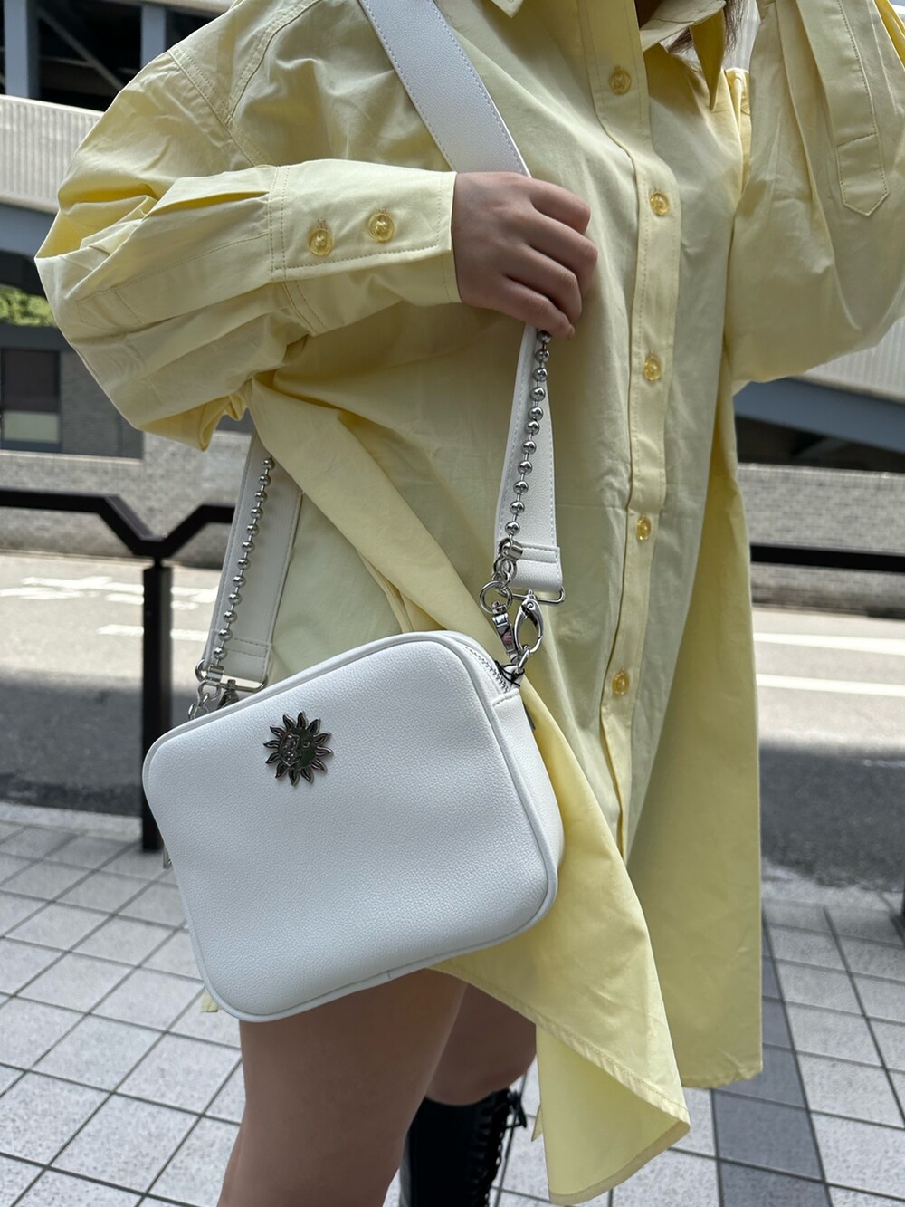 イエロー系のシャツ/ブラウス、ブラック系のブーツ、ホワイト系のショルダーバッグを着用したレディースの春コーディネートの6枚目の写真