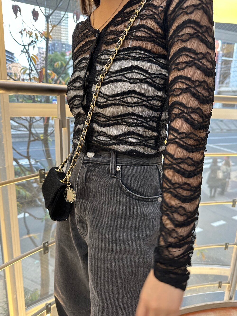 ブラック系のショルダーバッグ、ブラック系のデニムパンツ、ブラック系のTシャツ/カットソーを着用したレディースの冬コーディネートの5枚目の写真