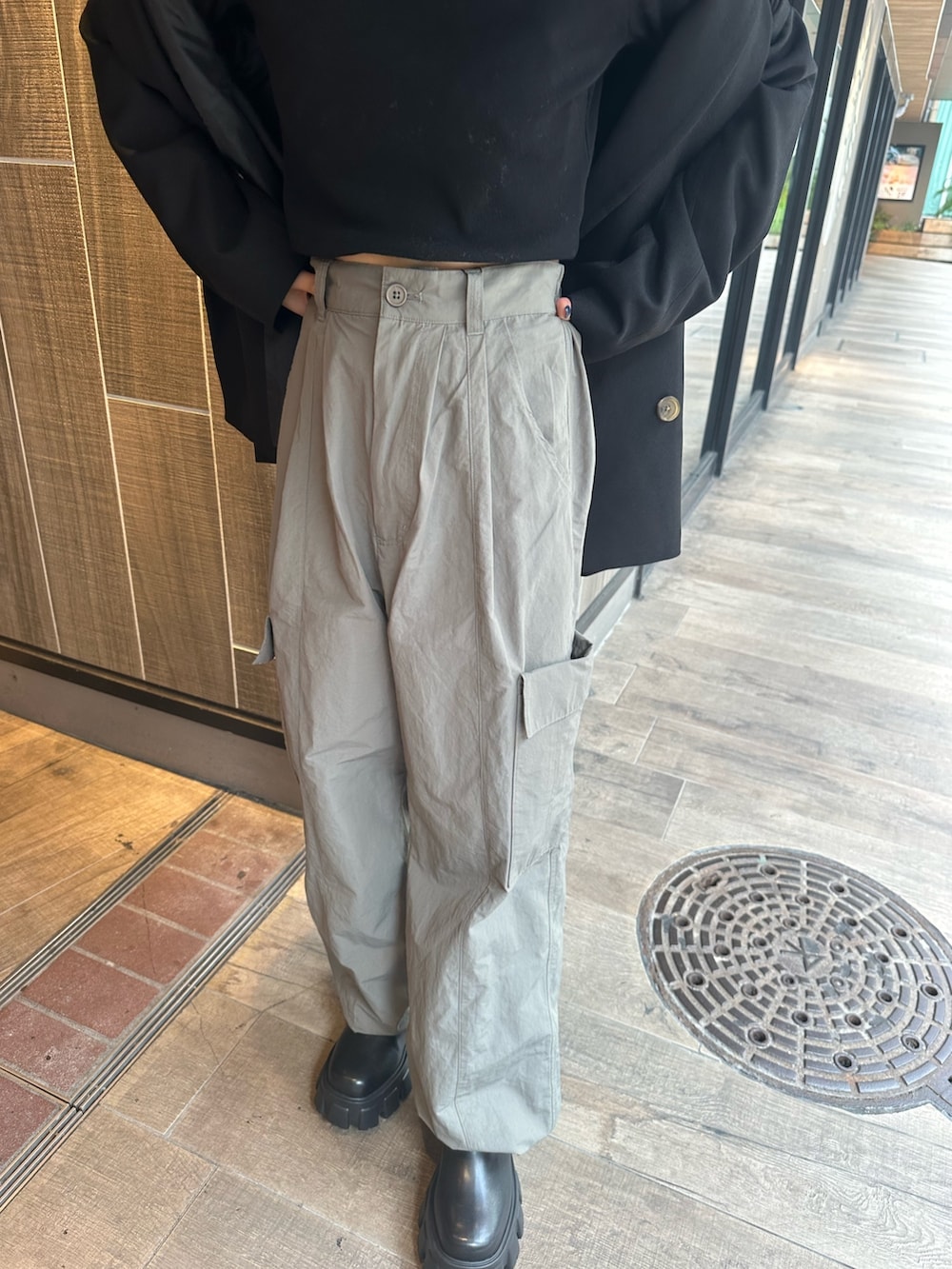 グレー系のカーゴパンツ、ブラック系のTシャツ/カットソー、ブラック系のブーツを着用したレディースの秋コーディネートの7枚目の写真