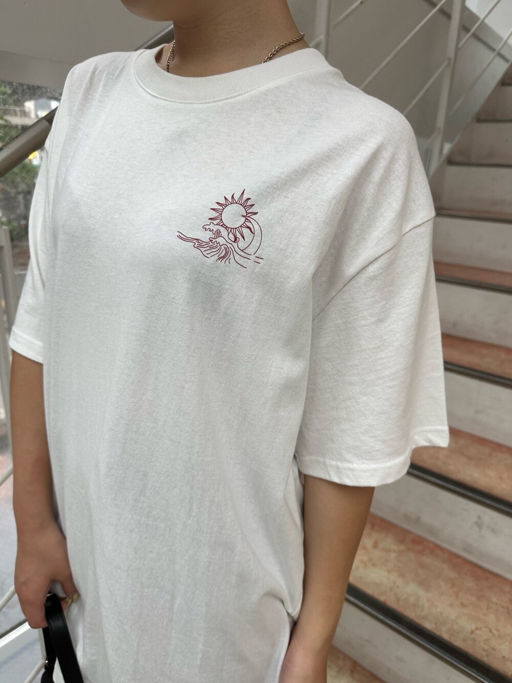 ホワイト系のTシャツ/カットソー、ブラック系のブーツ、ブラック系のハンドバッグを着用したレディースの夏コーディネートの5枚目の写真