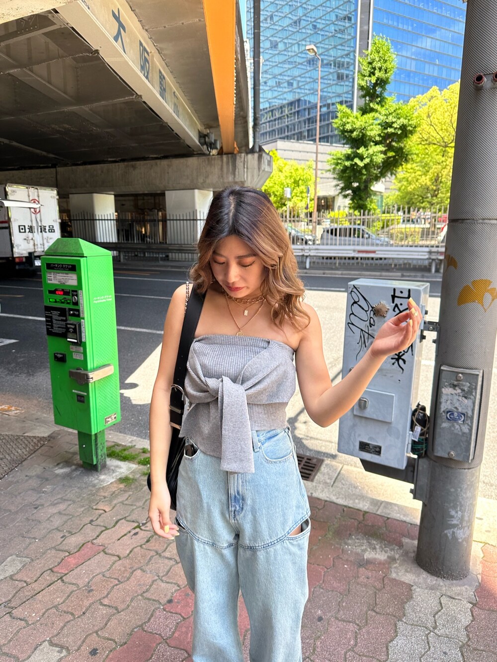 ブラック系のサンダル、ブラック系のショルダーバッグ、グレー系のチューブトップを着用したレディースの春コーディネートの4枚目の写真