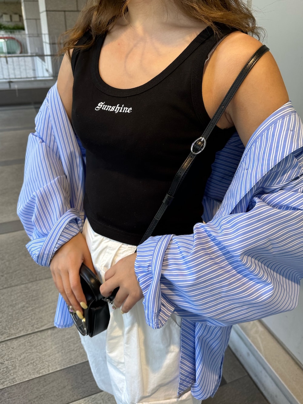 ブラック系のタンクトップ、ブルー系のシャツ/ブラウス、ホワイト系のカーゴパンツを着用したレディースの春コーディネートの5枚目の写真