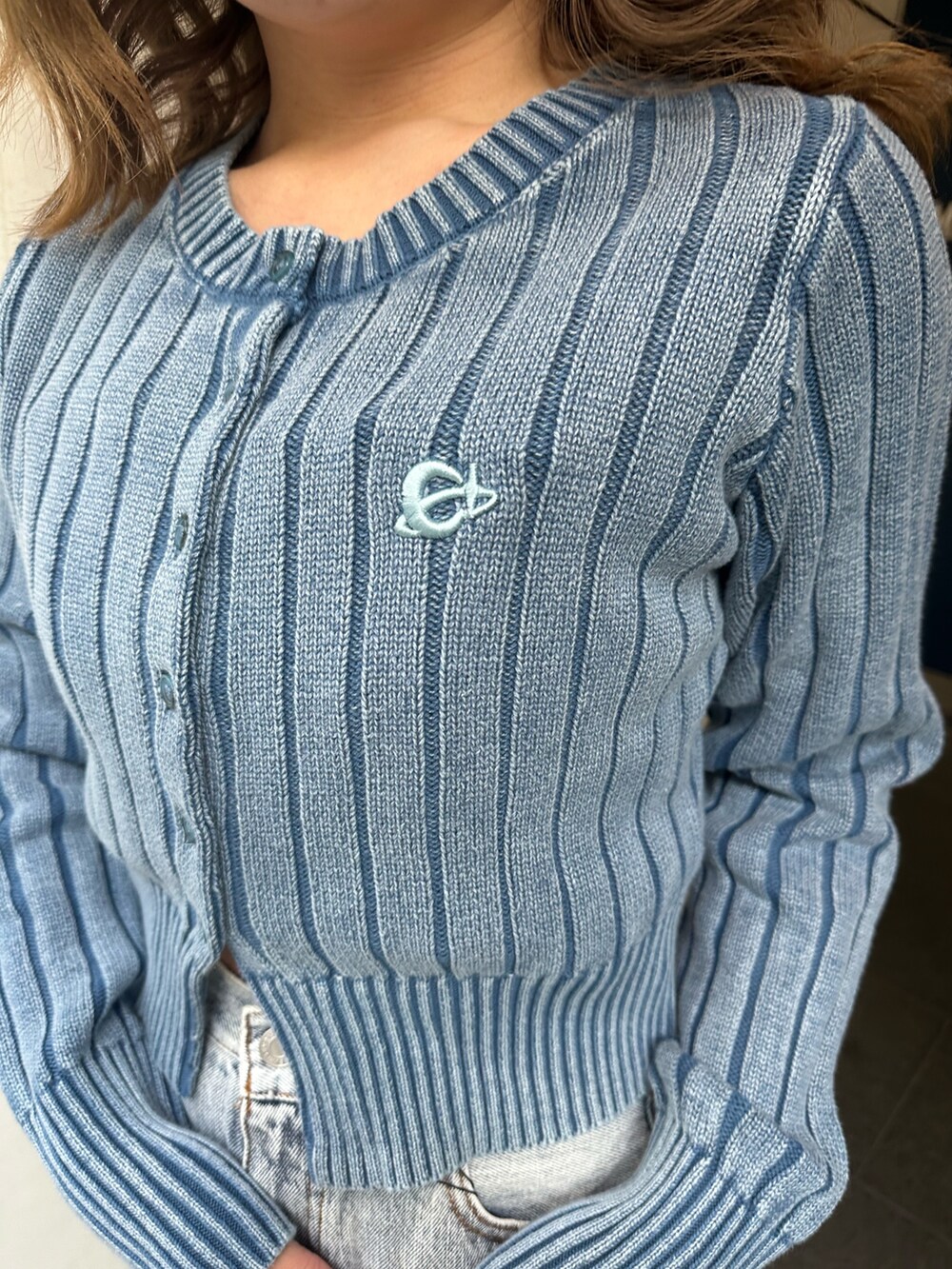 ブルー系のデニムパンツ、ブラック系のブーツ、ブルー系のカーディガン/ボレロを着用したレディースの冬コーディネートの6枚目の写真